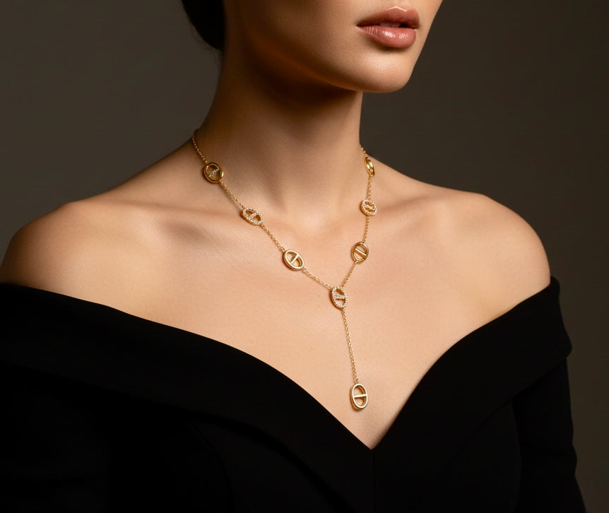 Gold charm necklace with chunky gold chain and symbolic charms worn on neck